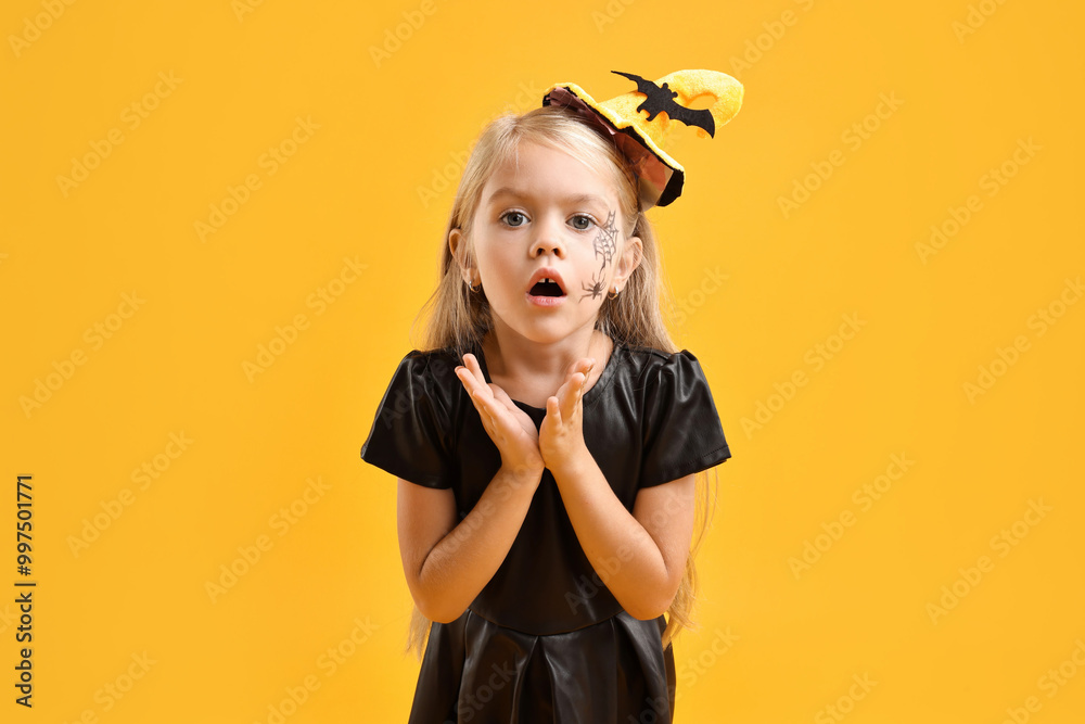 Wall mural Cute girl dressed like witch on yellow background. Halloween celebration