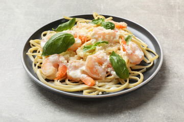 Tasty pasta with shrimps on light grey table, closeup