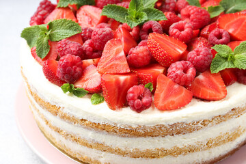Tasty sponge cake with fresh berries and mint on table, closeup