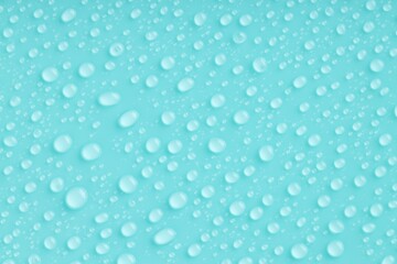 Water drops on turquoise background, top view