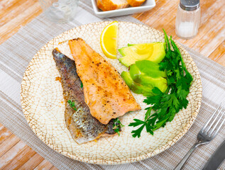 Fried trout fillet served with avocado is healthy dish in the kitchen