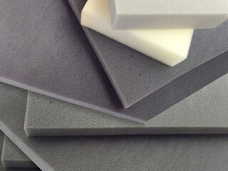 rectangular pieces of gray and white foam sponge neatly stacked. materials with different thickness