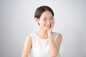 頬に手を当てるミドルの女性