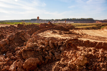Dirt road dug up by an excavator, soil heaps
