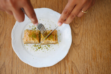 eating dessert baklava on a plate 