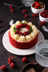 Red velvet cake, berries, glass and towel on gray background