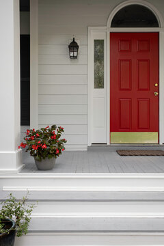 Red Door With Potted Plant On A Bright Front Porch