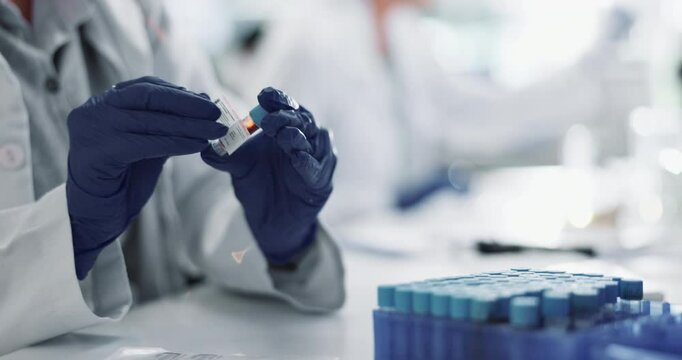 Hands, gloves and blood sample in lab with label for test, assessment or clinical analysis at pharma company. Scientist, person and glass container with dna, results and ppe with vaccine development