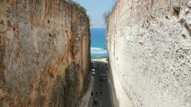 Aerial view of road in the middle of limestone cliffs and turquoise sea of Batu Barak beach in Bali, Indonesia