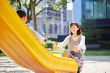 滑り台で遊ぶ子供と見守る保育士の女性