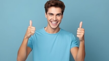 Fototapeta premium A cheerful man in a blue shirt giving two thumbs up in front of a blue backdrop, exuding positivity and enthusiasm.
