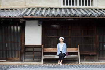 観光地のベンチに座る旅行中の日本人女性