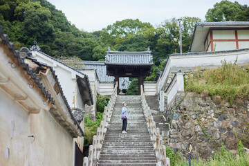 お寺への階段を登る旅行中の日本人女性