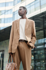Vertical low angle view shot self-confident young African American businessman wearing stylish...