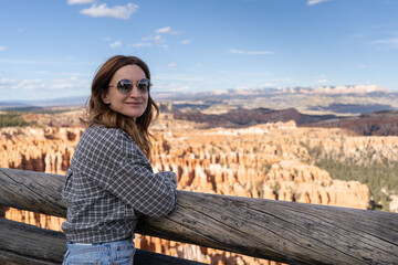 Woman standing at hoodoo on top of mountain looking at beautiful view. Bryce Canyon National Park, Utah, USA.