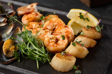 Assorted Seafood Fresh Shrimp, Scallops, and Mussels on a Dark Background with Vibrant Greens and Citrus