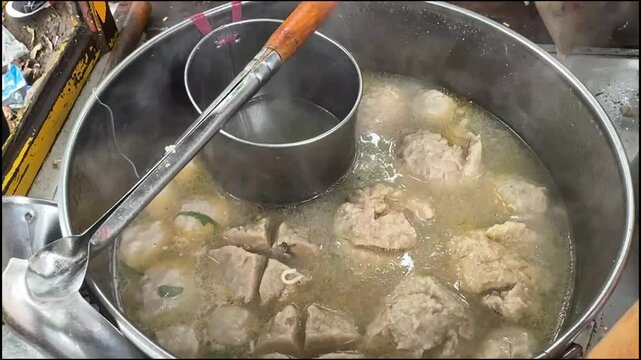 cooking and show of making bakso or meatballs, preparing bakso beef meatball, view of a bakso vendor preparing meatball dish for the buyer