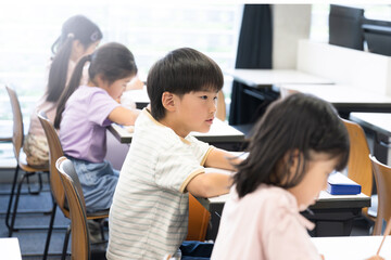 Elementary school children studying in an elementary school or cram school classroom Taking tests and exams	