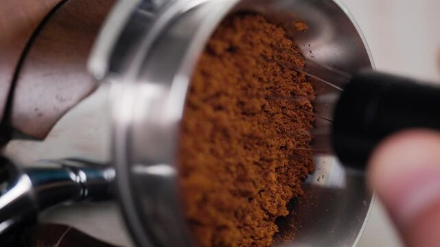 Barista making coffee presses using tamper