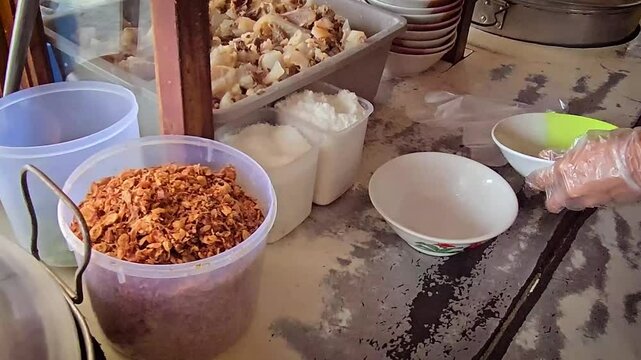 cooking and show of making bakso or meatballs, preparing bakso beef meatball, view of a bakso vendor preparing meatball dish for the buyer
