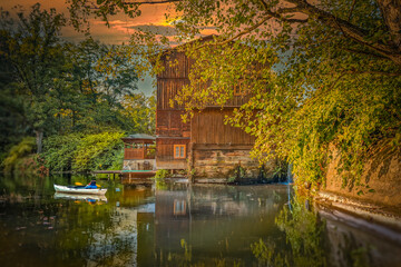 Small river flowing among fields, forests and its infrastructure.
