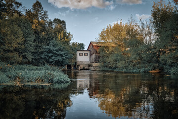 Small river flowing among fields, forests and its infrastructure.