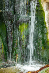 A waterfall with green moss growing on it