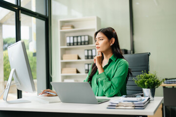 Obraz premium Young businesswoman working with working notepad, tablet and laptop documents talking on the smartphone, tablet