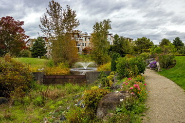 Autumn landscape. Residential District in Richmond City with pond and fountain, flowers, bushes and trees in the territory of residential complex, Vanсouver, British Columbia 