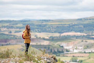 Naklejka premium Young woman enjoying nature.Hiking in the mountains, observing the landscape.Doing sports and physical activity.Let's take care of our natural surroundings and our environment.Moments of disconnection