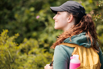 Young woman enjoying nature.Hiking in the mountains, observing the landscape.Doing sports and physical activity.Let's take care of our natural surroundings and our environment.Moments of disconnection