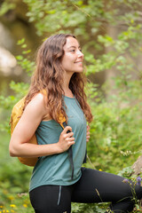 Fototapeta premium Young woman enjoying nature.Hiking in the mountains, observing the landscape.Doing sports and physical activity.Let's take care of our natural surroundings and our environment.Moments of disconnection