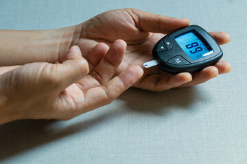 hand of people check diabetes and high blood glucose monitor with digital pressure gauge. Healthcare and Medical concept	