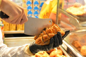 The chef is chopping up crispy fried pork legs.
