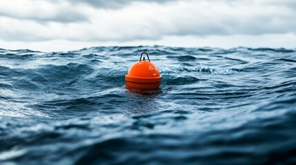 A bright orange buoy floats on the vast, turbulent ocean under a cloudy sky, symbolizing navigation and maritime safety.