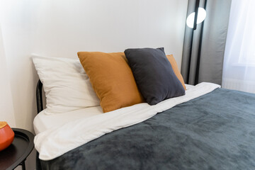 Experience ultimate relaxation in a cozy bedroom adorned with stylish pillows and soft bedding, all set in modern decor for an inviting atmosphere