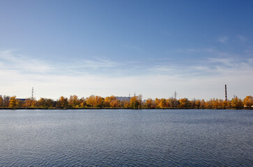 Beautiful european autumnal cityscape landscape. Scenery with dense trees near the river against...