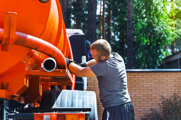 Sewer cleaning service - sewerage - repair workman on city street in working process to clean up...