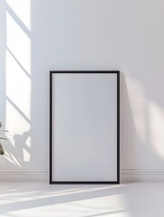 A minimalistic room featuring a blank framed mirror casting shadows, illuminated by natural light filtering through a window.