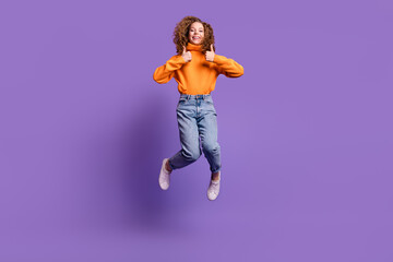 Full length portrait of lovely young girl jump thumb up wear sweater isolated on purple color...