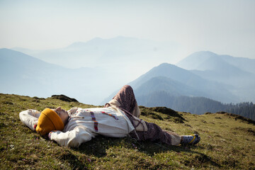 Fototapeta premium A Travler laying in grass and enjoy top of Tirthan Valley,Shangarh Himachal Pradesh, India.