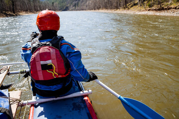 Obraz premium An adventurous kayaker embarks on a thrilling journey, skillfully navigating a serene and beautiful river during the enchanting springtime season