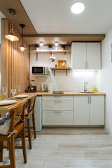 In a wellequipped kitchen, there is a lovely table surrounded by chairs, alongside a microwave for heating food, creating a functional and inviting space for meal preparation and gathering