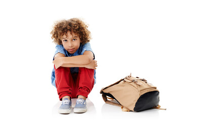Portrait, sad and child with backpack on a white background for depression, mistake and behavior. Education, upset and isolated unhappy kid with emotions for school, fail test and bullying in studio