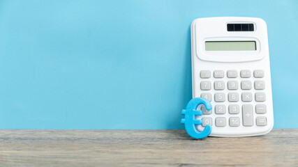 Euro Currency Symbol and Calculator on a Clean Blue Background with copy space.