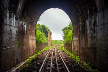 Obraz premium An old dark and abandoned railway tunnel passing through the countryside 