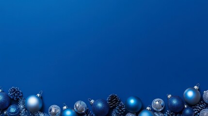 Fototapeta premium Festive blue christmas ornaments and pine cones on a blue background