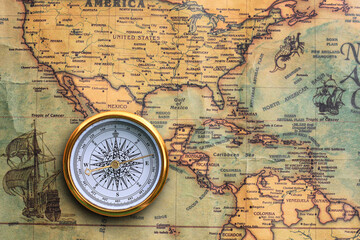 Classic round compass on background of old vintage map of world