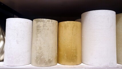 New wax candles on the shelf in the home decor store. Decorative white and gold candles. Home decor. New Year and Christmas candles. Handmade.