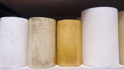 New wax candles on the shelf in the home decor store. Decorative white and gold candles. Home decor. New Year and Christmas candles. Handmade.